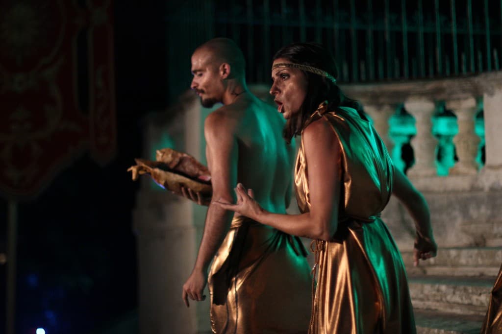 Two performers in gold costumes on stage